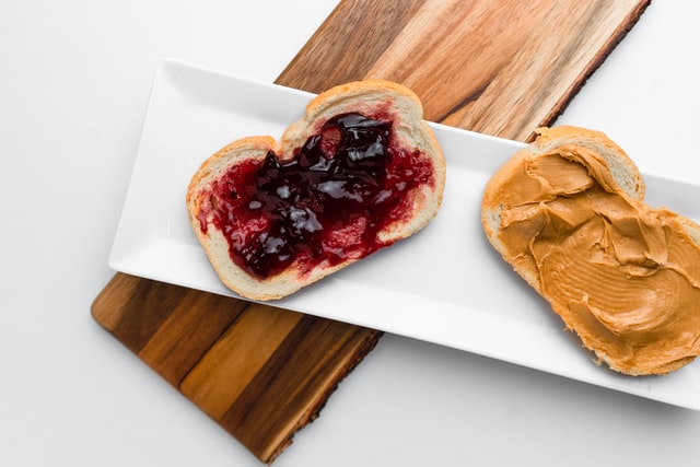 bread slices with jelly and peanut butter on white rectangular plate