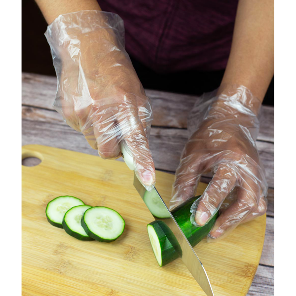 person wearing disposable gloves from Karat slicing a cucumber