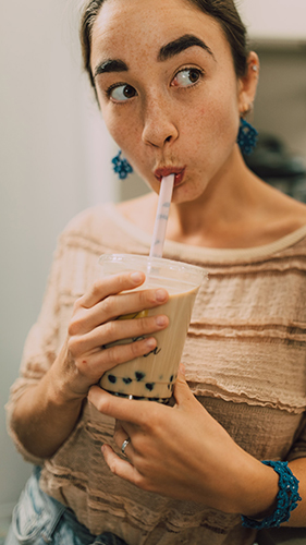 brunette woman sipping boba tea